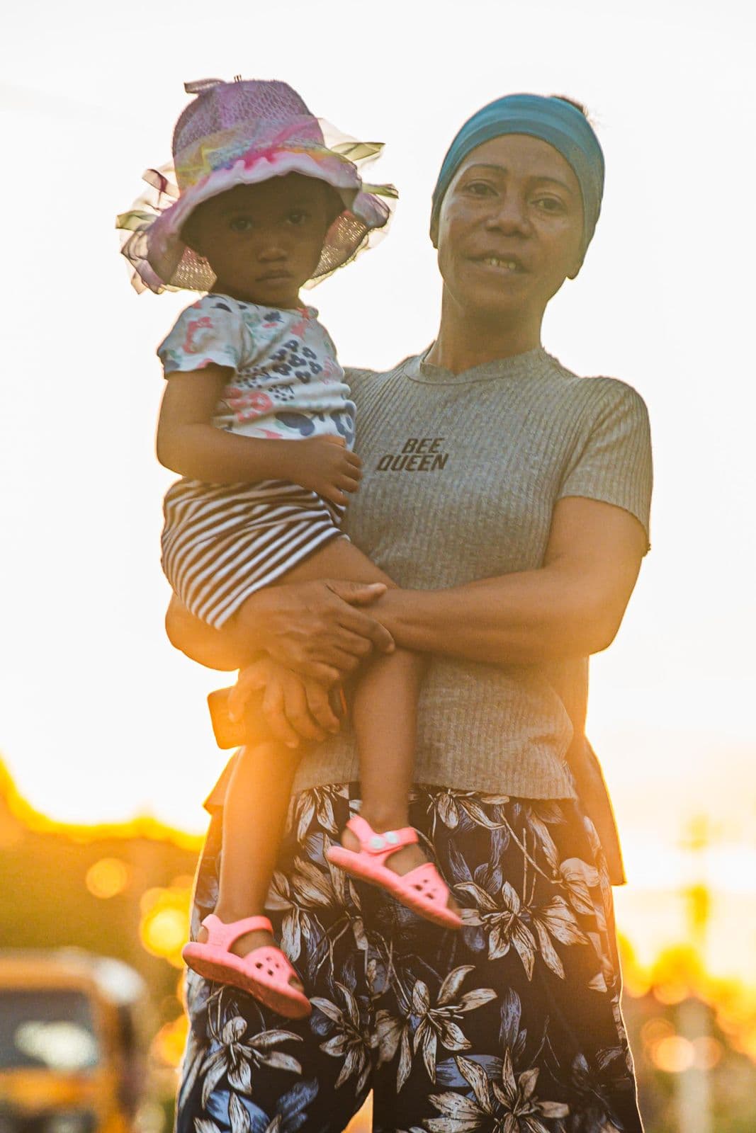 Une mère porte son enfant au coucher du soleil
