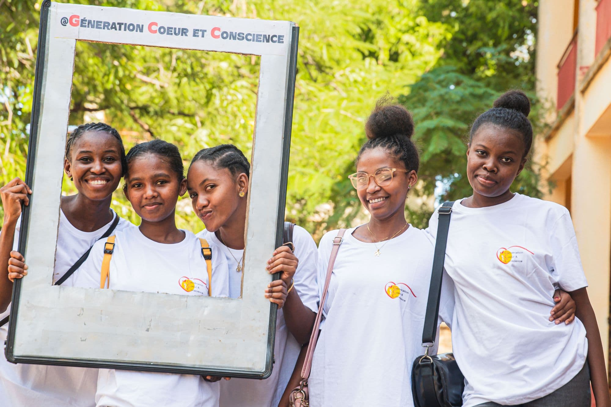 Jeunes filles de la Génération Cœur et Conscience, dont l'une tient un cadre « #Génération Cœur et Conscience »