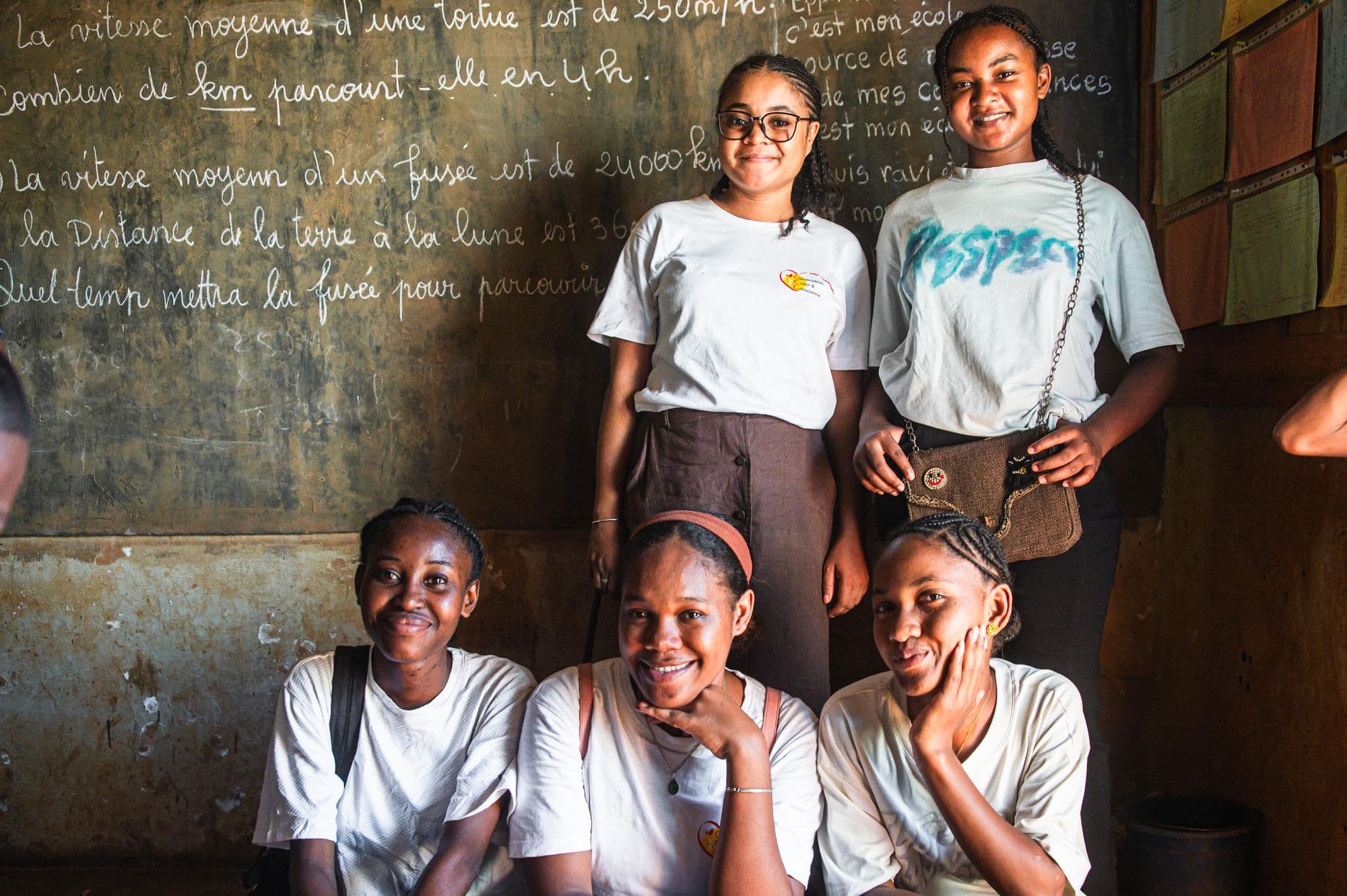Jeunes filles souriantes devant un tableau de classe