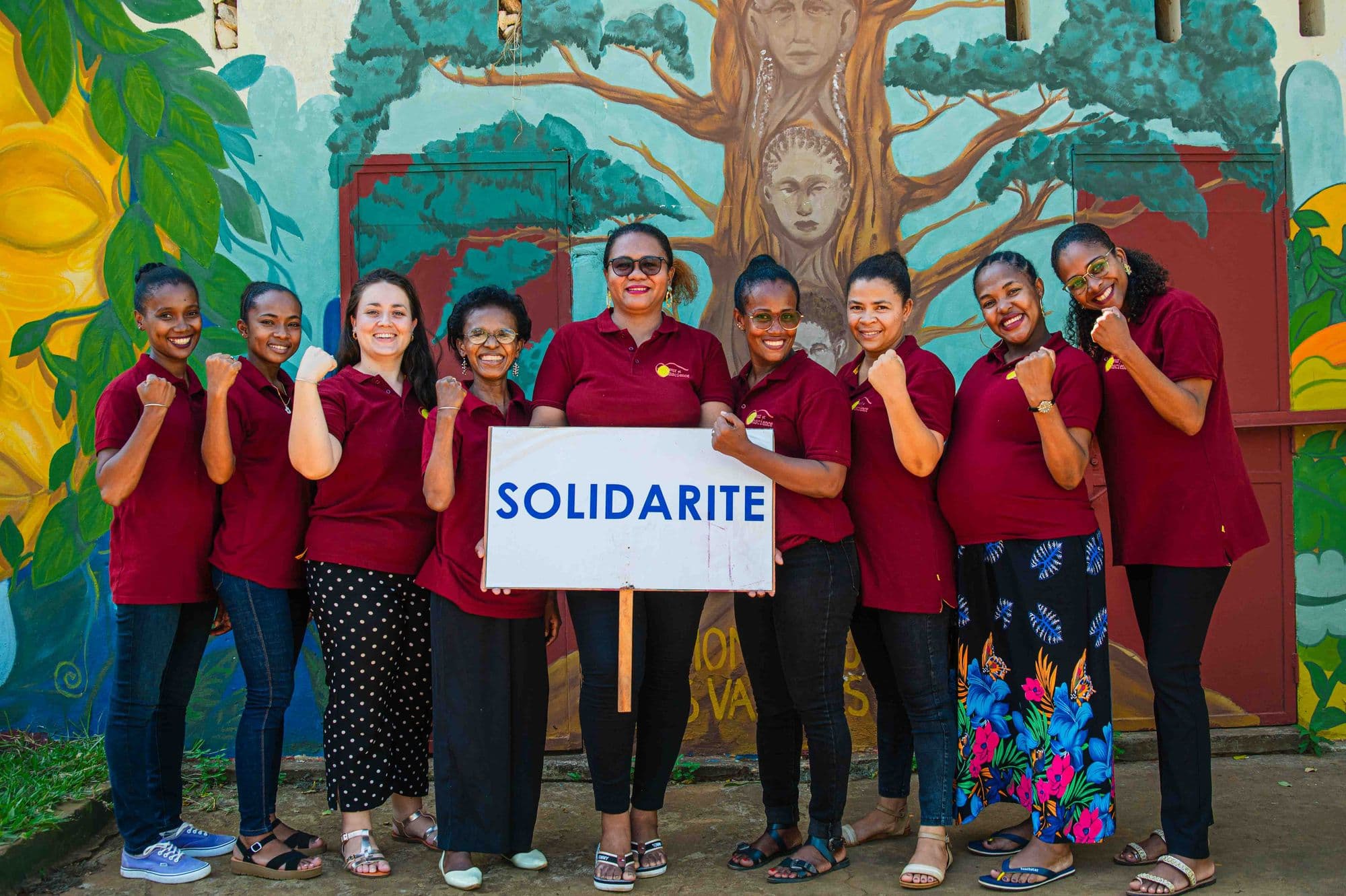 L’équipe de femmes de Cœur et Conscience, en polo bordeaux, autour d’une pancarte « Solidarité »